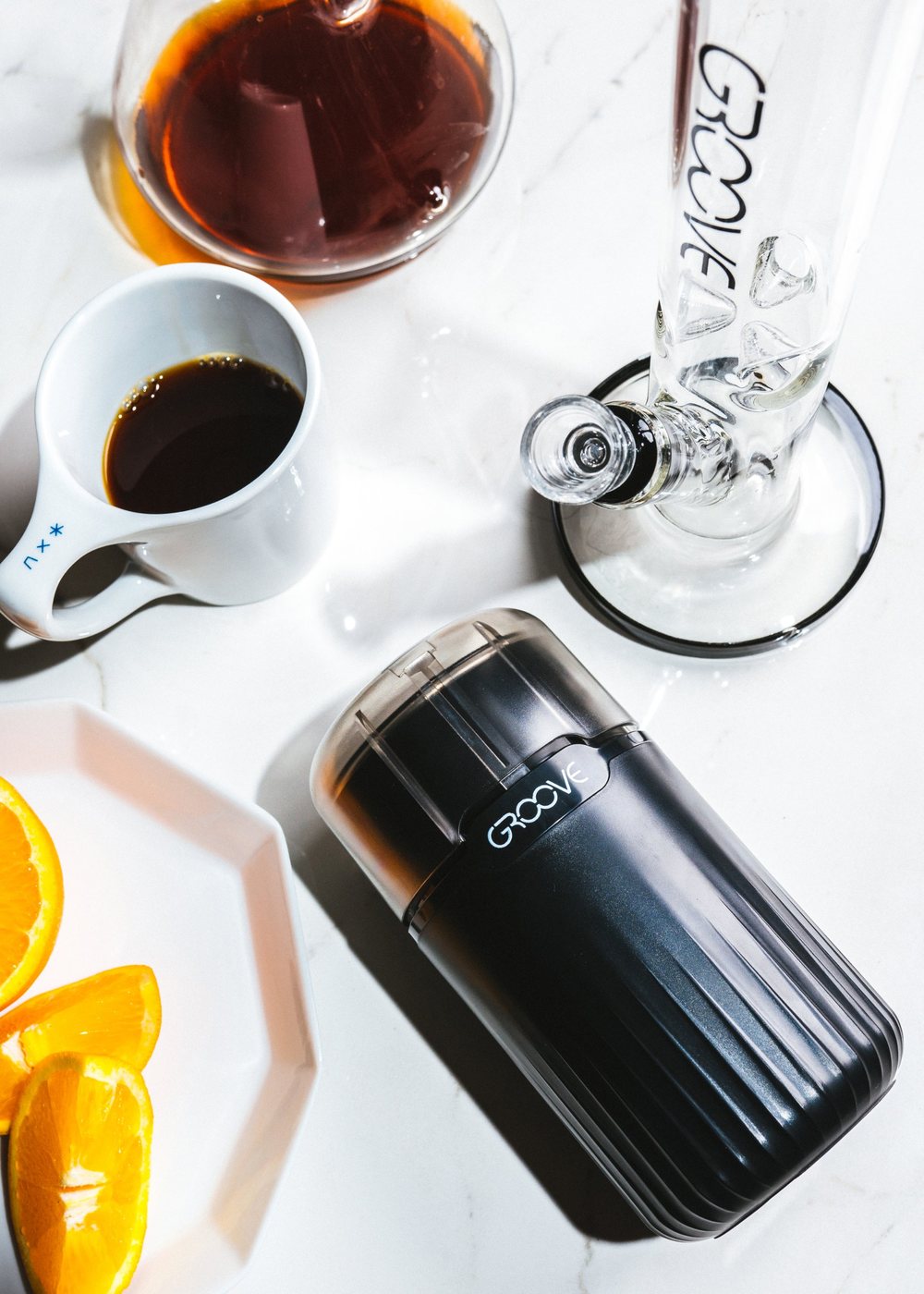 GROOVE electric grinder on a marble counter next to coffee and GROOVE glass